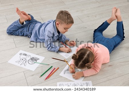 Cute little children coloring on warm floor at home. Heating system