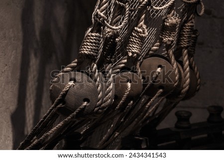 Rigging of an old sailing ship, old ropes in the dark Royalty-Free Stock Photo #2434341543