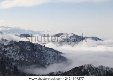 at the top of  Oi Qaragai mountain in Almaty city Clouds moving over the mountains with trees forest and Snow cover its top during 
