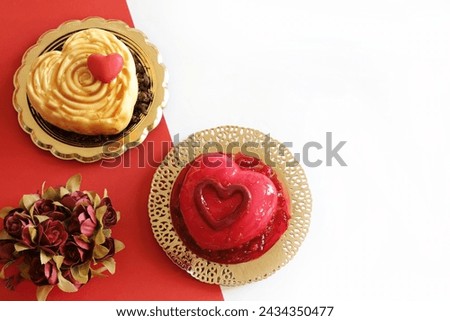 Two heart - shaped Valentine's day dessert isolated on red and white background. Valentine's day celebration. Overhead view. Copy space. 