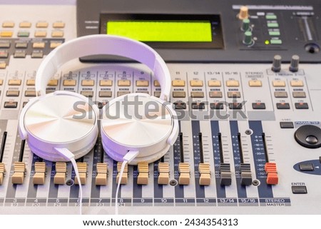 white headphone on audio mixing console. music background, recording concept