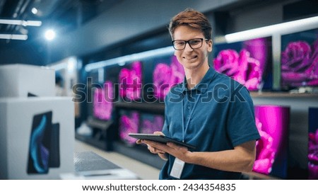 Portrait of an Organized Handsome Assistant in Home Electronics Store Optimizing Workflows with Tablet Computer. Young Happy Team Member Looking at Camera and Smiling