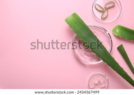 Flat lay composition with aloe vera leaves and cosmetic gel on pink background. Space for text