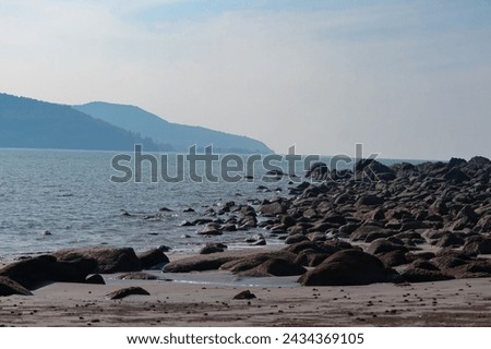 Wide angle of rocky sea shore and mountains in the background 