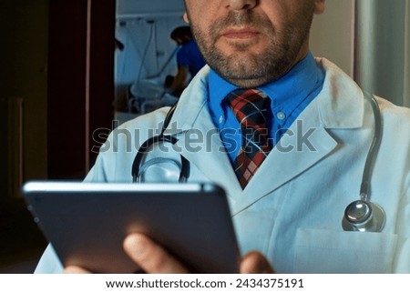 Professional doctor In Hospital Corridor Using Digital Tablet