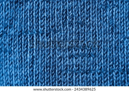 Cosy background or backdrop in textured warm blue textile wool material. Cotton and wool. Vertical fibres. Photo. Macro. Close-up.