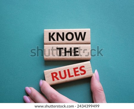 Know the rules symbol. Wooden blocks with words Know the rules. Beautiful grey green background. Businessman hand. Business and Know the rules concept. Copy space.