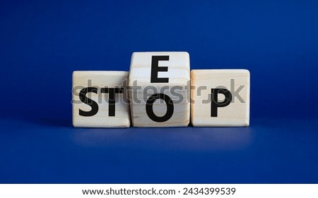Step vs Stop symbol. Wooden cubes with words Stop and Step. Beautiful deep blue background. Step vs Stop and business concept. Copy space