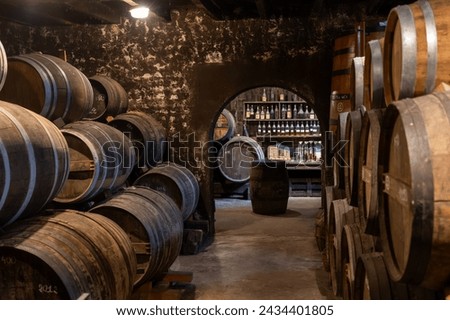 Aging process of cognac spirit in old dark French oak barrels in cellar in distillery house, Cognac white wine region, Charente, Segonzac, Grand Champagne, France Royalty-Free Stock Photo #2434401805