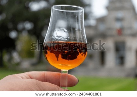 Tasting of aged in barrels cognac alcohol drink and view on old streets and houses in town Cognac, Grande Champagne, Charente, strong spirits distillation industry, France Royalty-Free Stock Photo #2434401881