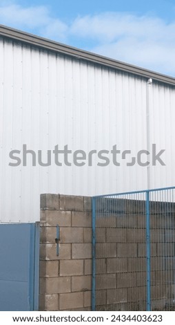 Fence by warehouse building in industrial area
