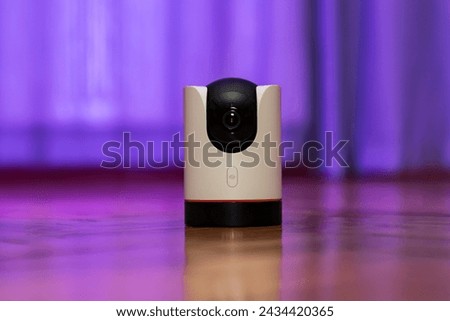 CCTV camera operating in home. Surveillance camera to protect and monitor your home through a mobile application. Home Security System Concept. smart camera on wooden table. 360 degrees rotating head Royalty-Free Stock Photo #2434420365