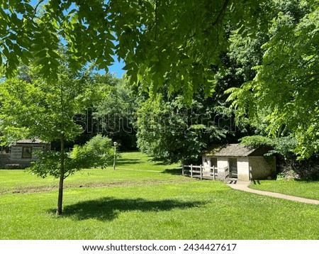 Historic Spring House exterior in the recreated and restored 1800 Pioneer Village at Spring Mill State Park, near Mitchell, Indiana with beautiful blue sky and vivid green trees and grass copy space. Royalty-Free Stock Photo #2434427617