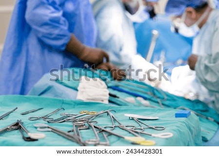 Sterile surgical instruments and tools including scalpels, scissors, forceps and tweezers arranged on a table for a surgery, Sterilized surgical instruments on the blue wrap Royalty-Free Stock Photo #2434428301