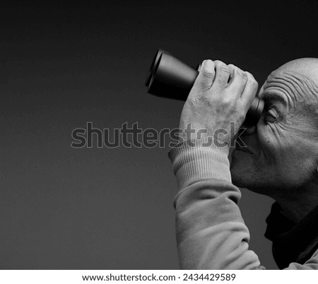 looking through binoculars with grey black background with people stock image stock photo	