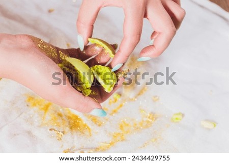 Broken macaroons in female hand. On a white background