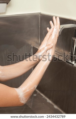 Surgeon having his hands surgically washed. A Caucasian doctor dressed in his right-hand profile with his hands full of foam and dressed in his surgical uniform.	 Royalty-Free Stock Photo #2434432789