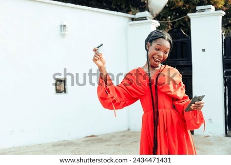 copyspace of free stock image of cheerful woman holding up credit card while looking at mobile phone
