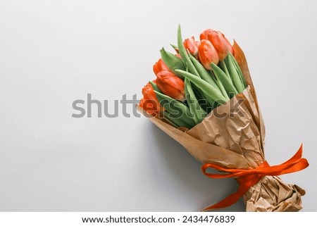 Bouquet of red tulips on pastel background. Mothers day, Valentines Day, Birthday celebration concept. Greeting card. Copy space for text, top view.