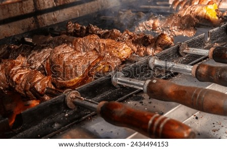 Brazilian style beef ribs Barbecue grill on skewers  at a churrascaria steakhouse in Brazil. Royalty-Free Stock Photo #2434494153