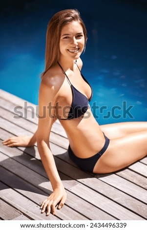 Portrait, woman and bikini by water in swimming pool for vacation, holiday and luxury in Mexico. Happy female person, gen z girl and outdoor with smile to sunbathe at resort, lodge and relax on deck