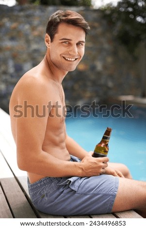 Man, relax and happy by swimming pool with beer to drink or chill on summer vacation, luxury and resort or villa. Male person, bottle and alcohol for refreshments on tropical holiday in Maldives.
