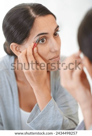 Face, cosmetics and tweezer with eyebrows of woman in mirror of home bathroom for grooming or hygiene. Beauty, cleaning or wellness with young person in apartment for morning hair removal routine Royalty-Free Stock Photo #2434498257