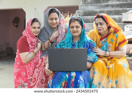 Concept of Rural Education, Woman empowerment, Women development and skilled women in india. Indian happy rural crowd women using on laptop in village. Royalty-Free Stock Photo #2434501475