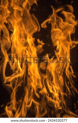 Fire flame element without smoke in red orange yellow color hot with dark background texture closeup detail abstract photography