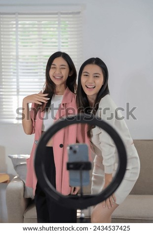 Young charming female influencers doing a vlog post at home, live streaming online.