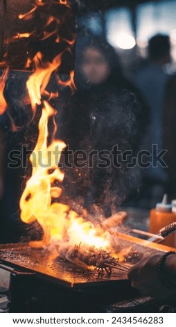 Capturing night photography of man in the market grilling satay in front of people, HD Picture 