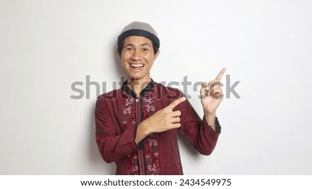excited asian muslim man gesturing pointing to the side on white background