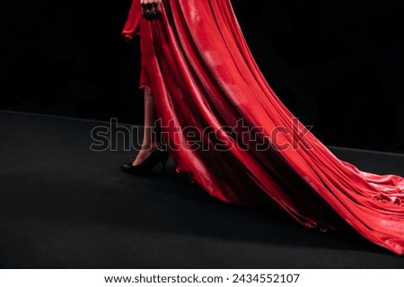 Red velvet dress with long hem. Female clothing elegant outfit. Side view
