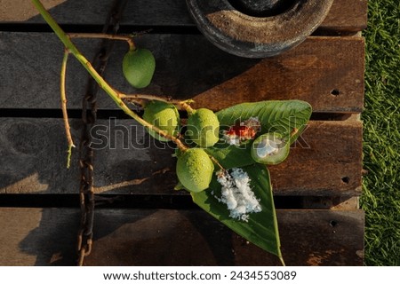 Green sliced mango with salt and pepper powder, on wooden background top view , kerala traditional uppumanga , text space, copy space, kannimanga