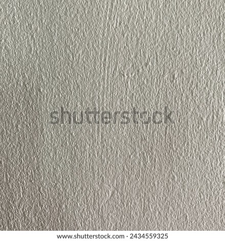 The background is a gray cement wall used as wallpaper. There are scratches.