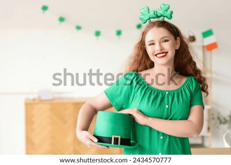 Young woman with Leprechaun's hat celebrating St. Patrick's Day at home