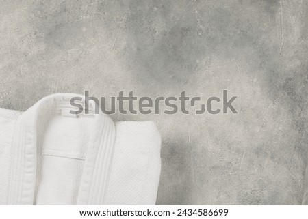 White kimono on gray background, top view. Space for text Royalty-Free Stock Photo #2434586699