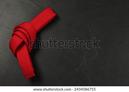 Red karate belt on gray background, top view. Space for text Royalty-Free Stock Photo #2434586755