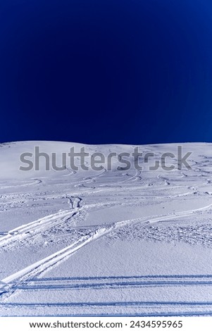 Looking up snow covered hill with ski tracks at Klingenstock mountain at Stoos on a sunny winter day. Photo taken February 13th, 2024, Klingenstock, Stoos, Canton Schwyz, Switzerland.
