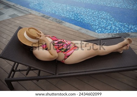 Overweight young woman orange swimsuit and straw beach sun hat relaxing in pool Happy plus size woman body positive Vacation Traveling in summer