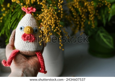 crochet chicken with spring flowers. Easter vibes. Hand-made crochet toy Royalty-Free Stock Photo #2434607537