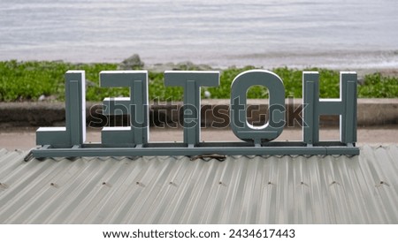 Large retro hotel sign on tinned roof overlooking ocean on tropical island destination in Southeast Asia