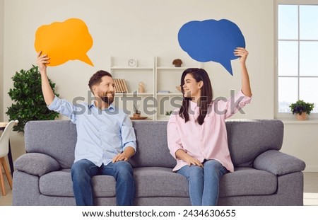 Young happy couple sofa sitting with speech balloons above, man, woman pair happy communication, dialog. People express feeling, ideas, good conversation, discourse, chatting in relations, thinking Royalty-Free Stock Photo #2434630655