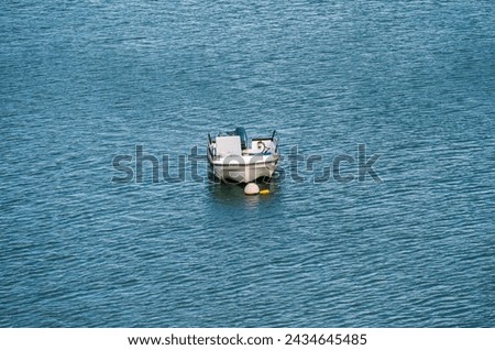 A boat anchored at shallow water in the sea with gentle waves