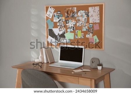 Stylish workplace with vision board and laptop Royalty-Free Stock Photo #2434658009