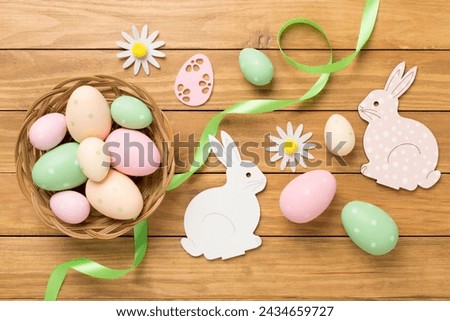 Easter bunny with eggs on color background, top view