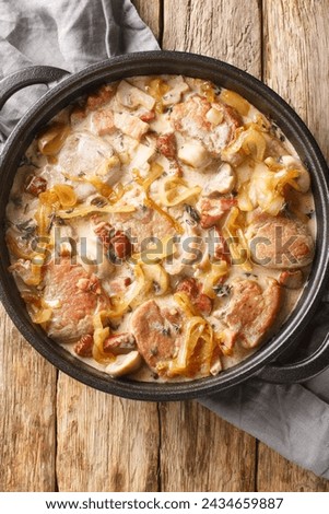 Danish pork tenderloin that is coupled with onions, bacon and mushrooms all doused in a creamy sauce closeup on the pan on the table. Vertical top view from above
 Royalty-Free Stock Photo #2434659887