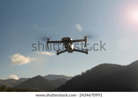 Drone with camera flying over the mountains