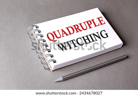 Quadruple Witching word on a notebook on grey background Royalty-Free Stock Photo #2434678027
