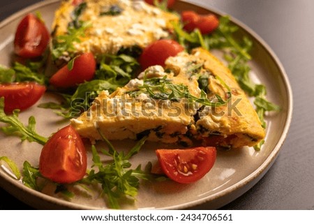 delicious spring frittata for a perfect brunch with arugula and cherry tomatoes close-up
